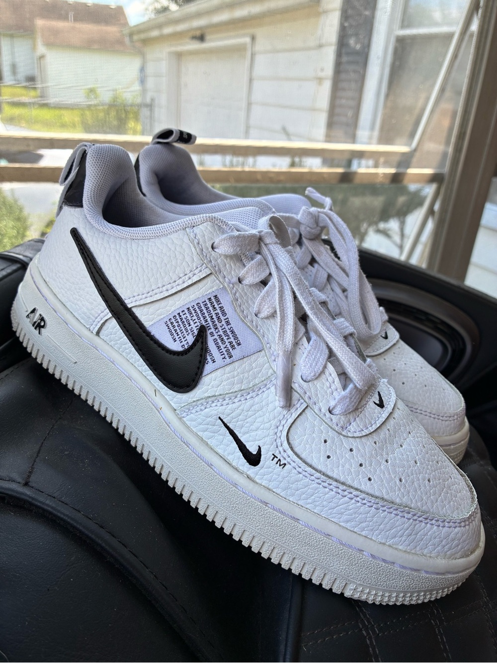 Classic Nike Air Force 1 Low sneakers in white with black Swoosh detailing.